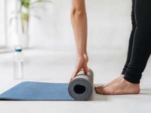 Femme qui déoule son tapis de Yoga